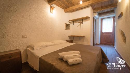1 dormitorio con 1 cama con 3 toallas en Il Tempo B&B, en Cleto