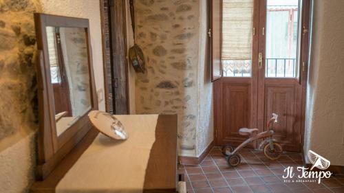 Una habitación con una mesa, un espejo y un scooter. en Il Tempo B&B, en Cleto