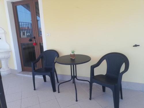 Tollo的住宿－Irma House，一张桌子,两把椅子,一张桌子,上面有植物
