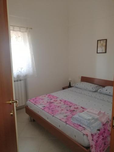 una camera da letto con un letto con lenzuola rosa e una finestra di Irma House a Tollo