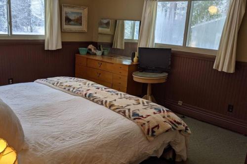 a bedroom with a bed and a desk with a computer at Whole home, private lake, sauna, WFH office in Michigamme