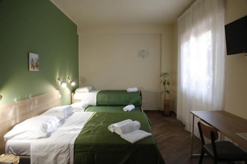 a hotel room with two beds with towels on them at All’Anoneto B&B in Catona