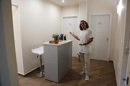 a man standing at a counter in a room at All’Anoneto B&B in Catona