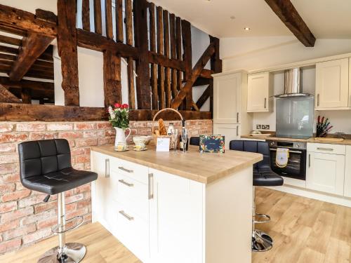 a kitchen with white cabinets and a brick wall at Swallows Rest in Montgomery