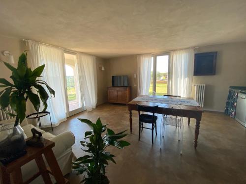 a living room with a table and chairs and windows at casa il colle con piscina privata in Strada