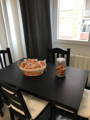 a black table with a basket of pretzels on it at Alojamiento El Cantal in Santoña
