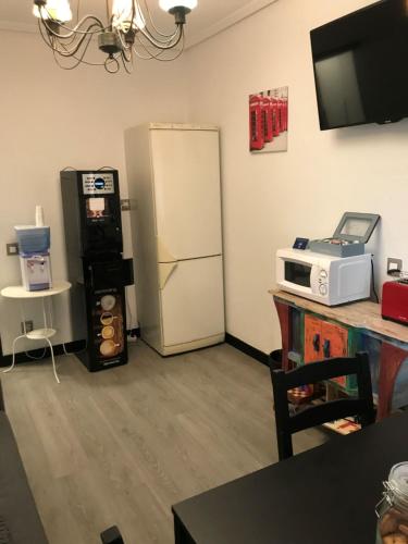 a living room with a refrigerator and a microwave at Alojamiento El Cantal in Santoña