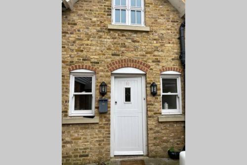 a brick house with a white door and windows at Central Townhouse Whitstable in Whitstable