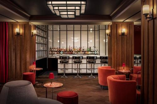 a restaurant with a bar with red chairs at Riggs Washington DC in Washington