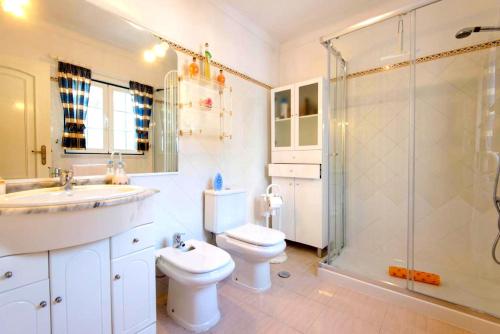 a bathroom with a sink and a toilet and a shower at Villa - Duna Parque Group in Vila Nova de Milfontes