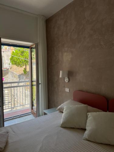 ein Schlafzimmer mit einem Bett und einem großen Fenster in der Unterkunft Amalfi Casa Andreina in Amalfi