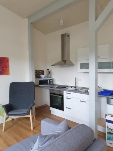 cocina con sofá y silla en una habitación en An der Schafsweide, en Aukrug