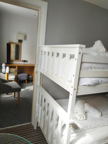 a bedroom with a white bunk bed and a mirror at Cumberland Hotel - OCEANA COLLECTION in Bournemouth
