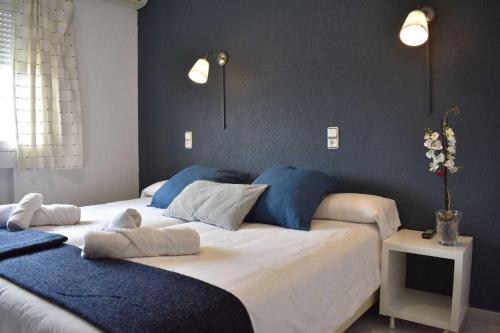 a bedroom with two beds with blue and white pillows at Hotel El Ancla in Villanueva de la Cañada