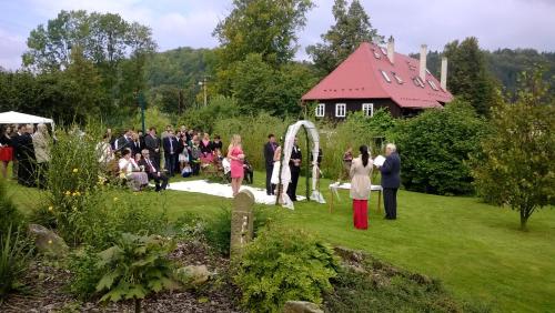 a group of people standing around a wedding in a garden at Pension Laura in Chřibská