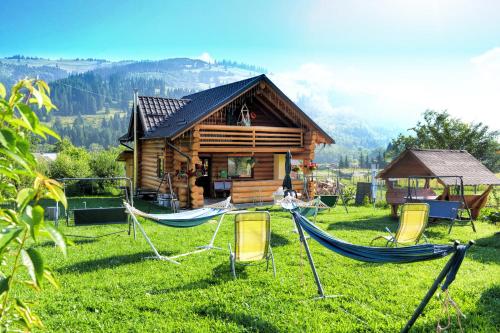 a log cabin with hammocks in front of it at Casa Maia in Vatra Dornei