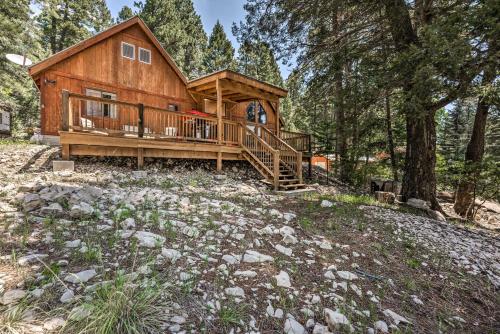 a log cabin with a large deck in the woods at Peaceful and Private Cloudcroft Cabin with Deck! in Cloudcroft