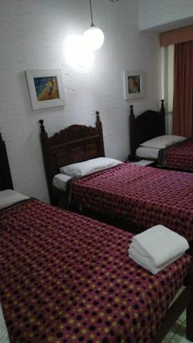 a hotel room with two beds with red sheets at Hotel Atlântico Avenida in Rio de Janeiro