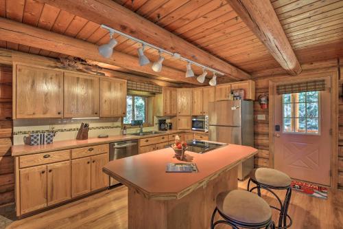 a kitchen with wooden cabinets and a island in a cabin at Large Cabin with Fire Pit and Grill on 34 Acres! in Sagle