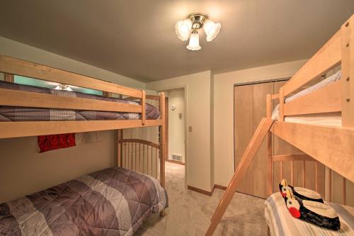 a bedroom with two bunk beds and a staircase at Large Cabin with Fire Pit and Grill on 34 Acres! in Sagle