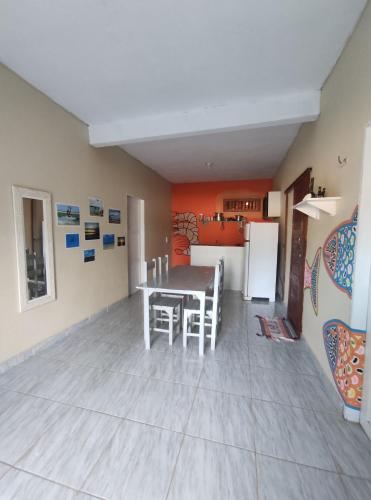 una sala da pranzo con tavolo e frigorifero di Vila da Sereia hostel e pousada a Icaraí