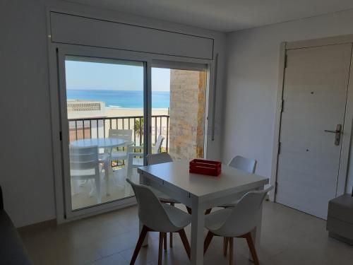 a dining room with a table and chairs and a balcony at Apartamentos Dins Mar Apto. 7 in Torredembarra