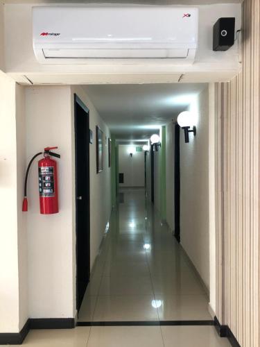 a hallway in a hospital with a fire extinguisher on the wall at Hotel Francis in Culiacán