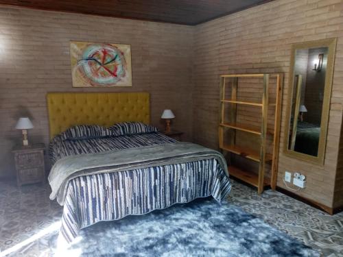 a bedroom with a king sized bed and a mirror at Eco Chalés Águas Claras in Lumiar