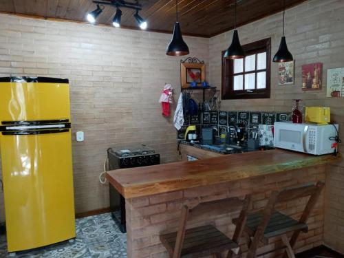 a kitchen with a yellow refrigerator and a counter at Eco Chalés Águas Claras in Lumiar