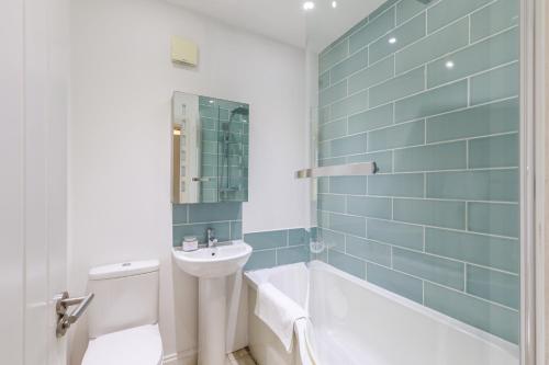 a bathroom with a sink and a tub and a toilet at 3Bed house with games room, hot tub & free parking in Brighton & Hove