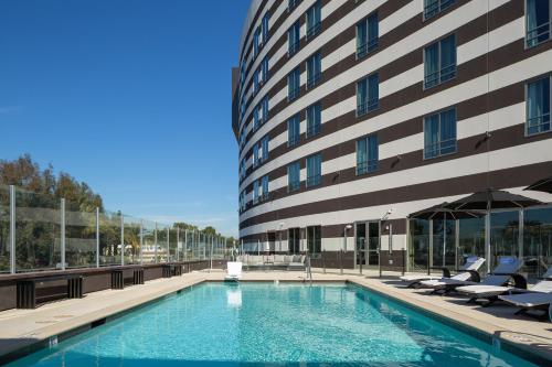 a swimming pool in front of a building at Parkwest Bicycle Casino in Bell Gardens
