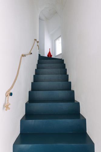 a blue staircase with a blue floor and a window at Infinito Bianco in Polignano a Mare
