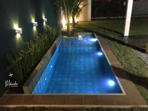 basen w nocy z niebieskimi światłami w obiekcie Morada dos Cataventos (Frente Mar) w mieście Barra de Camaratuba