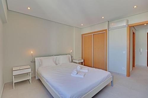 a bedroom with a white bed with a towel on it at Armacao de Pera Ocean View by Homing in Armação de Pêra