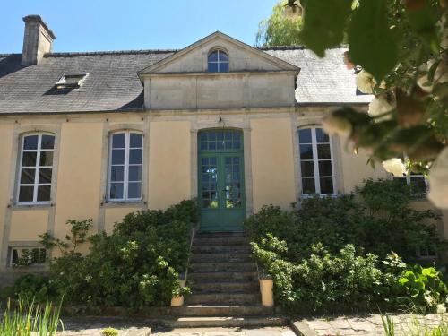 an old house with a green door and stairs at Maison d'hôtes de Charme in Bayeux