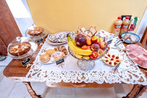 a table with a bowl of fruit and other foods at B&B BONE NOVELLE in LʼAquila