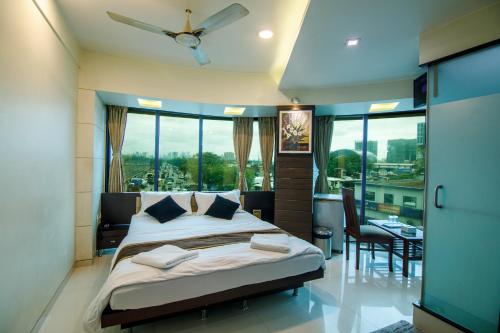 a bedroom with a bed and a large window at La Hotel Metro near BKC in Mumbai