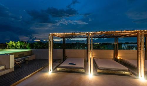 a patio with a canopy bed and a pool at Unho Tulum in Tulum