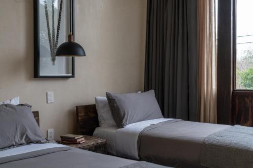 a hotel room with two beds and a window at Unho Tulum in Tulum