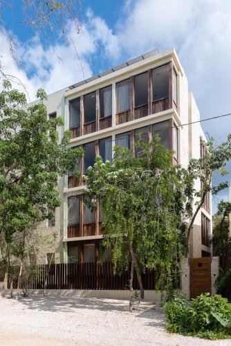 an apartment building with a fence in front of it at Unho Tulum in Tulum