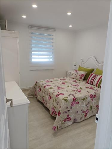 a white bedroom with a bed and a window at O Chaleco in San Ciprián