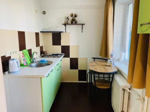 a small kitchen with a sink and a table at Apartments on Polytech in Kyiv