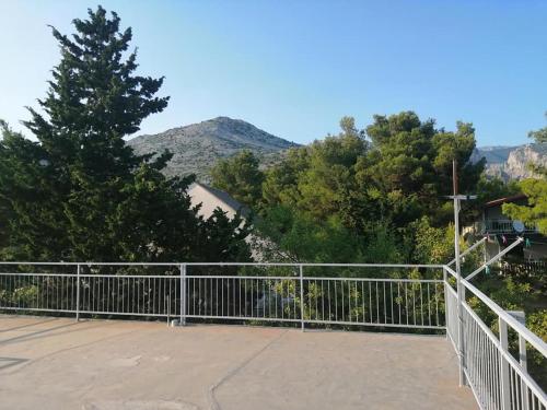 a metal fence with trees and mountains in the background at Holiday house Lara in Starigrad-Paklenica