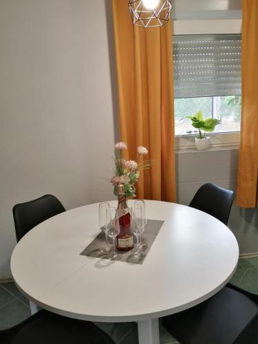 a white table with a vase of flowers on it at Holiday house Lara in Starigrad-Paklenica