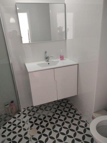 a bathroom with a sink and a mirror and a toilet at נוף לחוף in Ashqelon