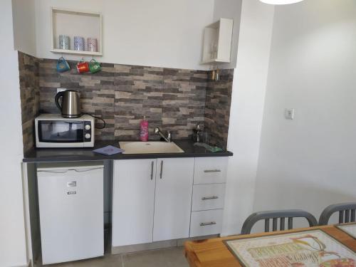 a kitchen with a sink and a microwave at נוף לחוף in Ashqelon