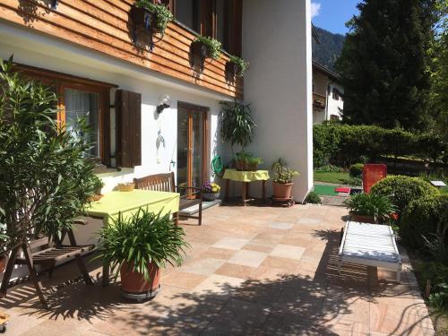 a patio with a table and potted plants in front of a house at Landhaus Renata Bayrischzell in Bayrischzell