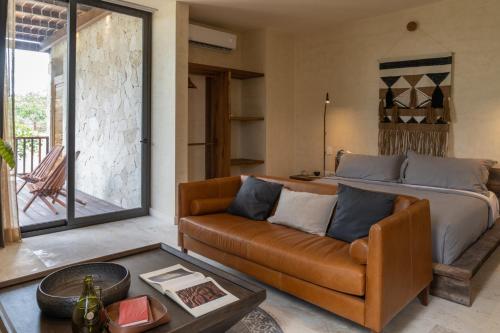 a living room with a couch and a bed at Unho Tulum in Tulum