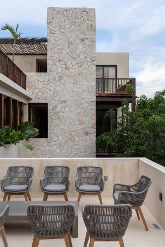 a group of chairs sitting on a patio at Unho Tulum in Tulum