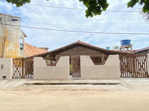 a building with a brown roof with a tower at Casa para temporada - Praia de Alcobaça - Bahia - em frente ao Condomínio Gaivotas in Alcobaça